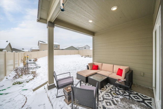 snow covered patio with a fenced backyard and outdoor lounge area