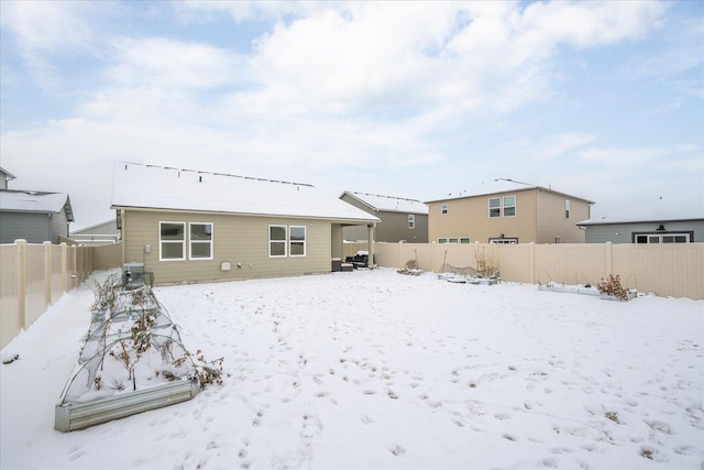 snow covered property with a fenced backyard