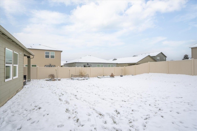 snowy yard featuring a fenced backyard