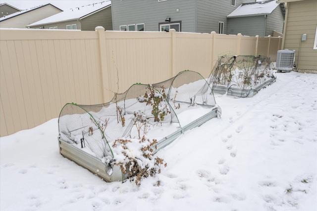 snowy yard with central air condition unit and fence