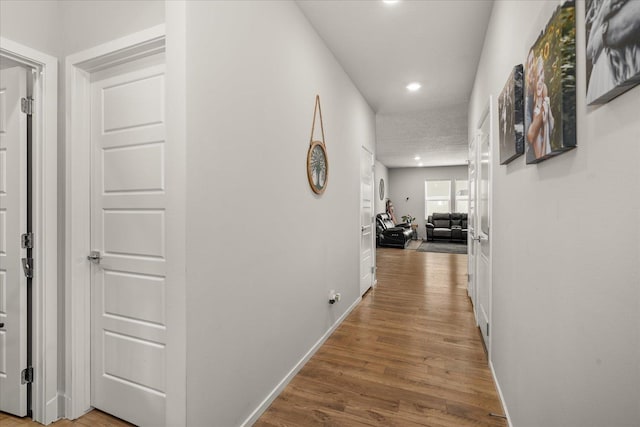 corridor with recessed lighting, baseboards, and wood finished floors