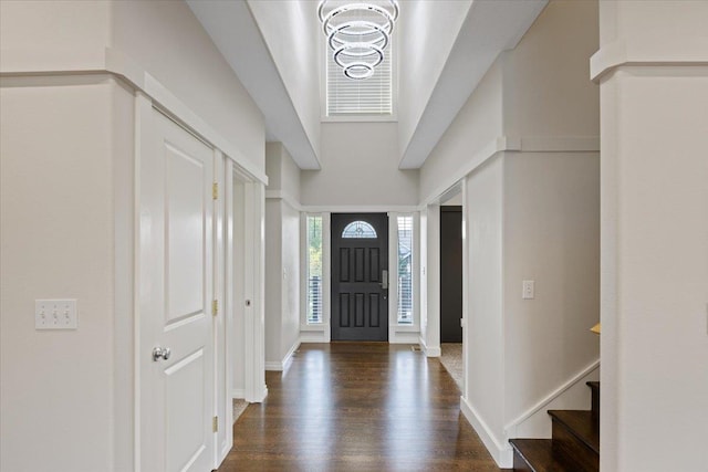 foyer entrance featuring dark hardwood / wood-style floors and a chandelier