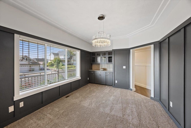 unfurnished bedroom featuring a notable chandelier and dark carpet