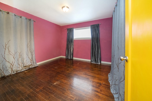 unfurnished room with dark wood-type flooring