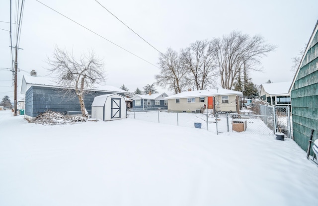 snowy yard featuring a storage shed