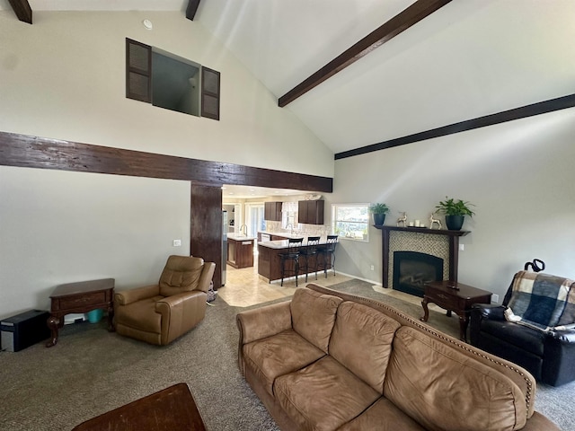 carpeted living room featuring a tile fireplace, high vaulted ceiling, and beam ceiling