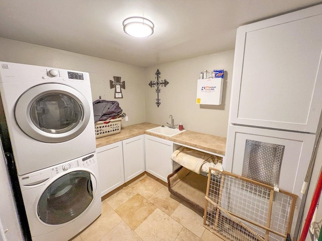washroom featuring a sink, cabinet space, and stacked washer / drying machine