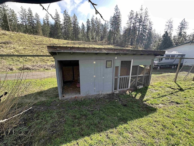 view of outbuilding with fence and an outdoor structure