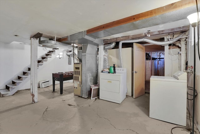 basement featuring baseboard heating, washer and dryer, and heating unit