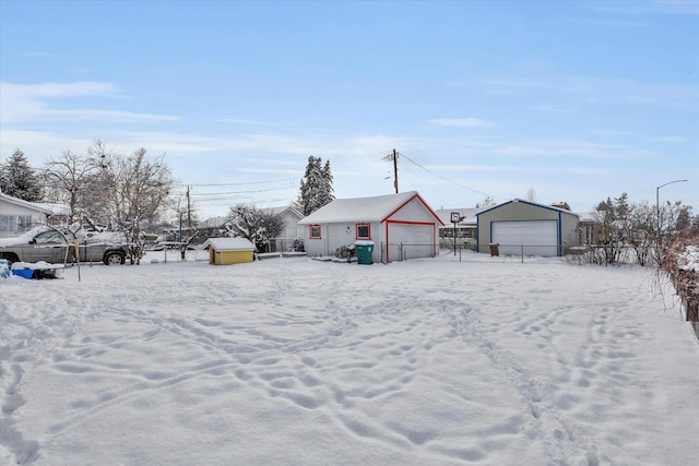 yard covered in snow with a garage and an outdoor structure