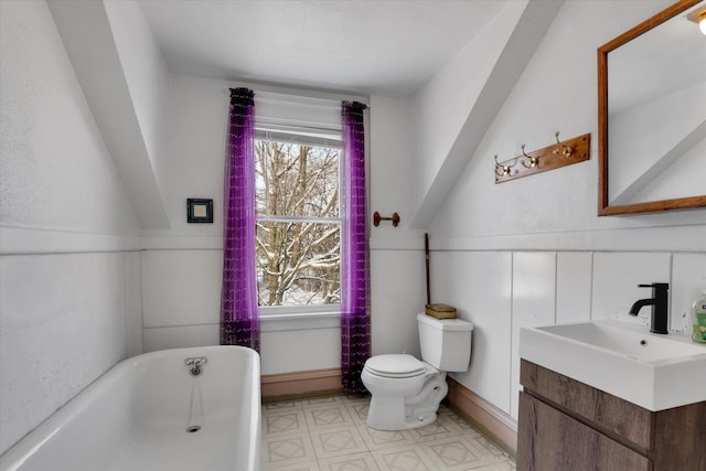 bathroom featuring a tub to relax in, toilet, and vanity