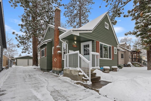 bungalow-style home with a garage and an outbuilding