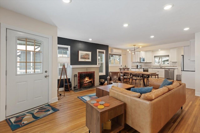 living room with sink, a chandelier, and light wood-type flooring