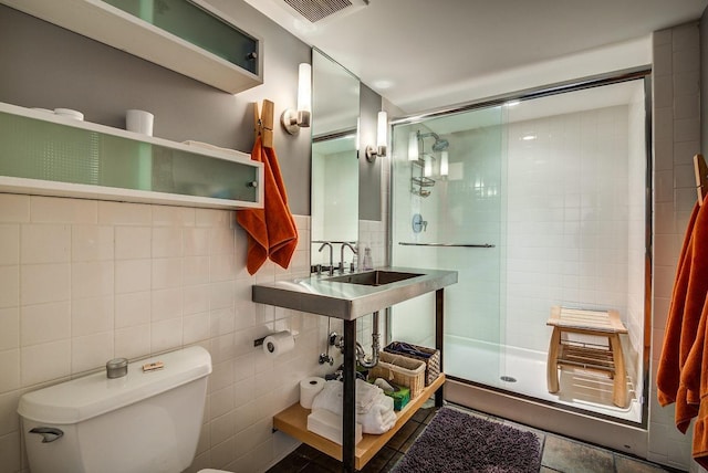 bathroom featuring walk in shower, toilet, and tile walls