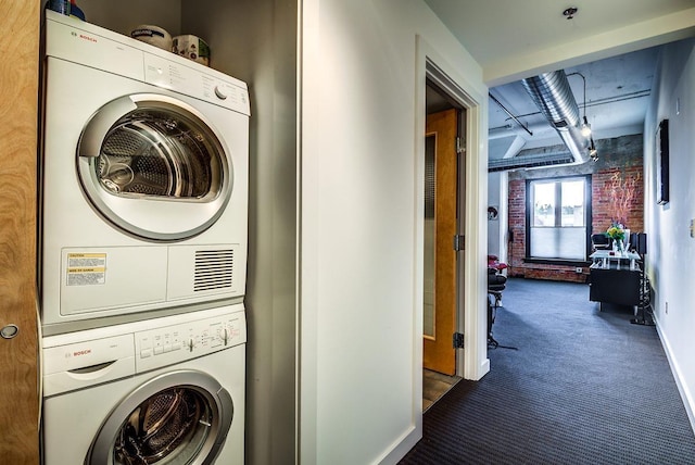 clothes washing area featuring stacked washer and clothes dryer and carpet floors