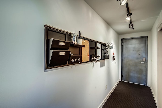 interior space with dark carpet and rail lighting