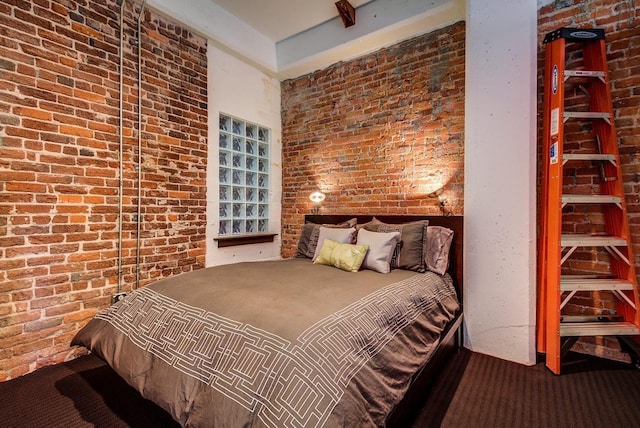 carpeted bedroom with brick wall