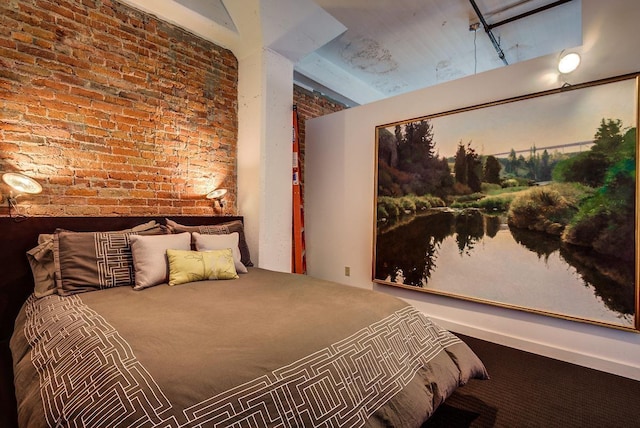 bedroom featuring brick wall