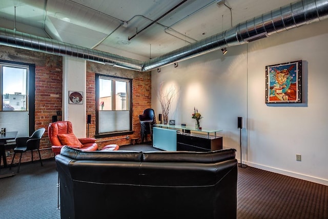 home theater with brick wall and dark carpet