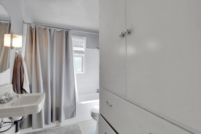 bathroom with a sink, toilet, and shower / tub combo with curtain