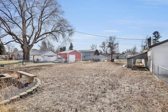 view of yard featuring a garage, a residential view, and fence