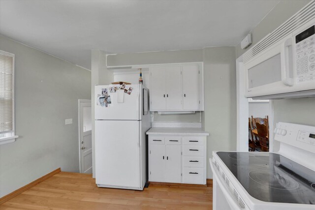 kitchen featuring light countertops, light wood-type flooring, white appliances, and white cabinetry
