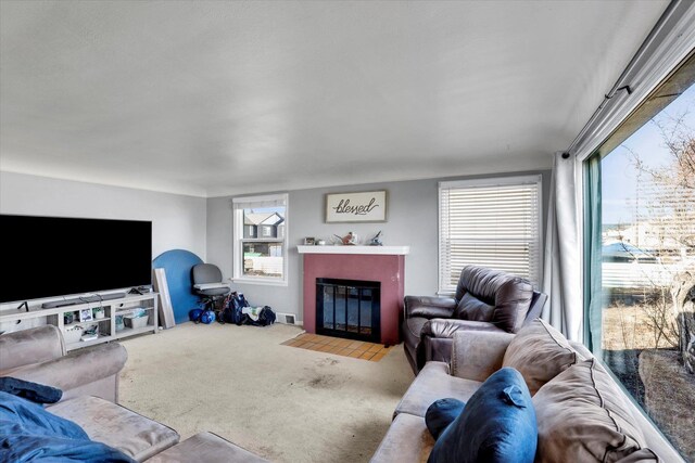living room featuring carpet and a fireplace with flush hearth