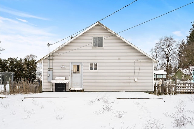 view of snow covered rear of property