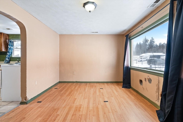 unfurnished room with light hardwood / wood-style floors and a textured ceiling