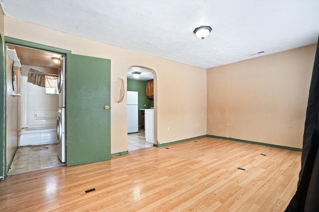 empty room featuring washer / dryer and light hardwood / wood-style floors