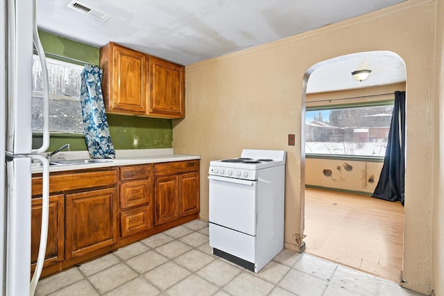 kitchen with sink, white appliances, and a wealth of natural light