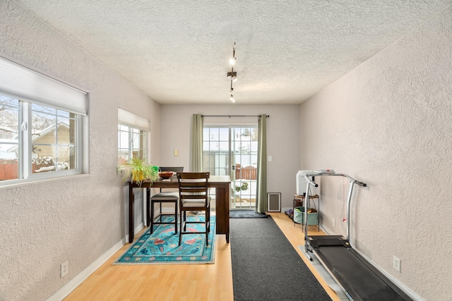 dining area featuring hardwood / wood-style flooring and a textured ceiling