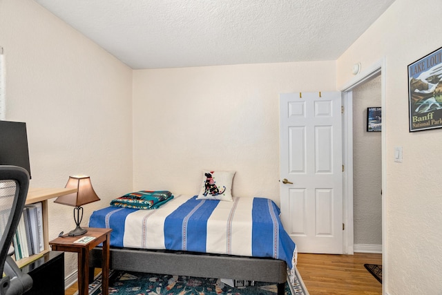 bedroom with wood-type flooring and a textured ceiling