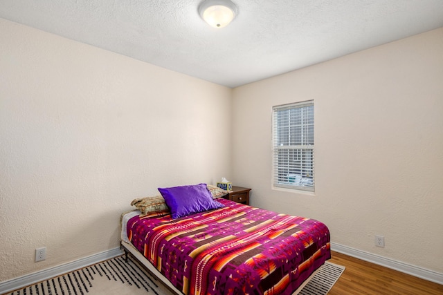 bedroom featuring hardwood / wood-style floors and a textured ceiling