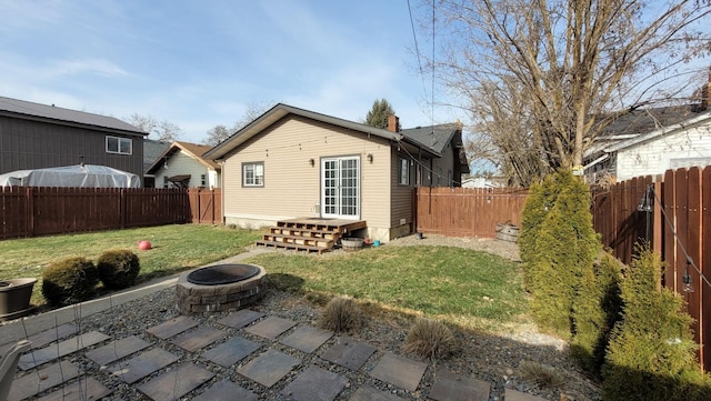 rear view of house with a yard, a patio area, and a fire pit