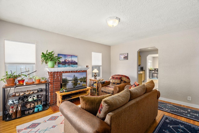 living room with a textured ceiling and light wood-type flooring