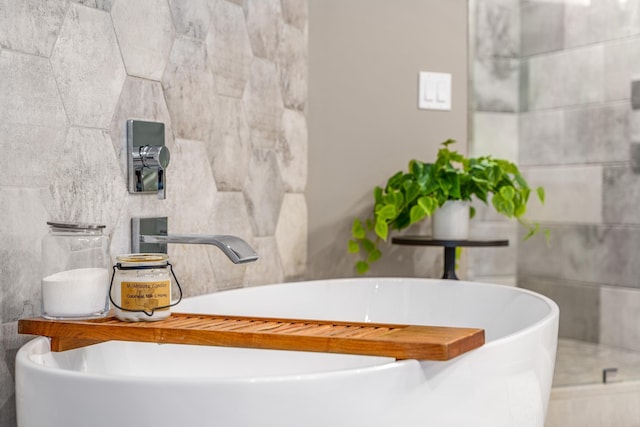 bathroom with sink, a bath, and tile walls