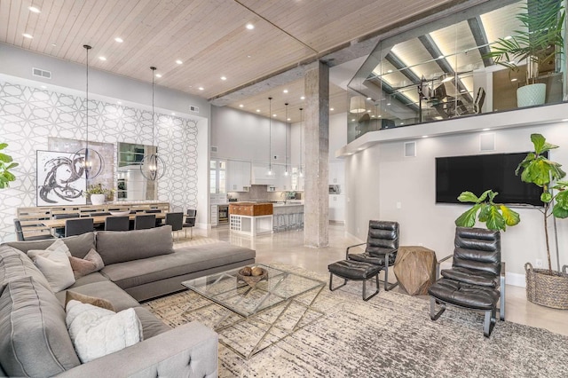 living room featuring an inviting chandelier, wood ceiling, and a high ceiling