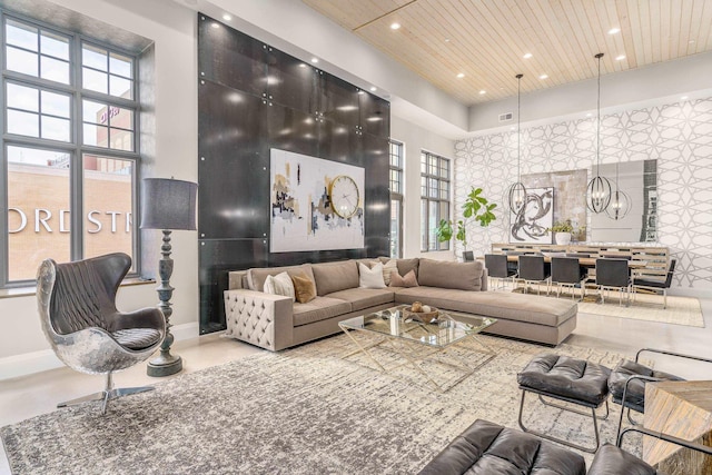 living room featuring a high ceiling, a notable chandelier, and wood ceiling