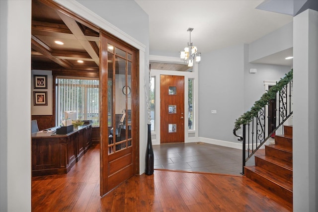 entrance foyer featuring dark hardwood / wood-style floors, coffered ceiling, a chandelier, and beamed ceiling