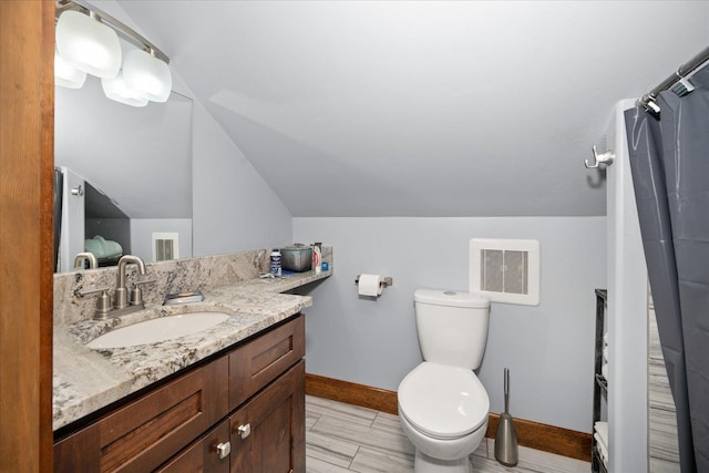 bathroom with vanity, lofted ceiling, and toilet