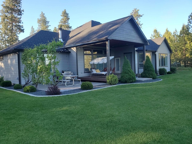 back of property featuring a patio area and a lawn