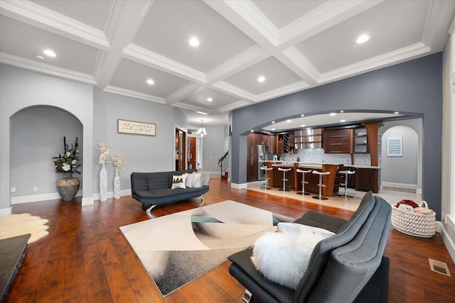 living room featuring hardwood / wood-style flooring, crown molding, coffered ceiling, and beam ceiling