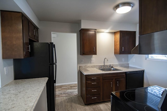 kitchen featuring light hardwood / wood-style flooring, sink, dark brown cabinets, and black appliances