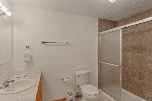 bathroom with vanity, a shower with shower door, a textured ceiling, and toilet