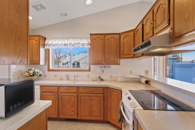 kitchen featuring vaulted ceiling, sink, stainless steel range with electric cooktop, and backsplash