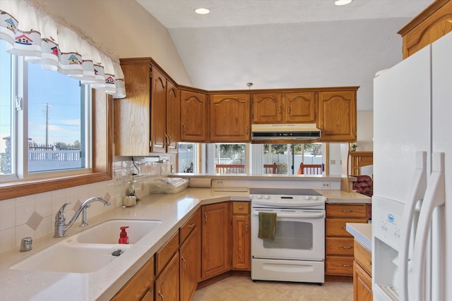 kitchen with white appliances, a healthy amount of sunlight, sink, and lofted ceiling