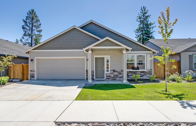 craftsman inspired home with a garage and a front lawn