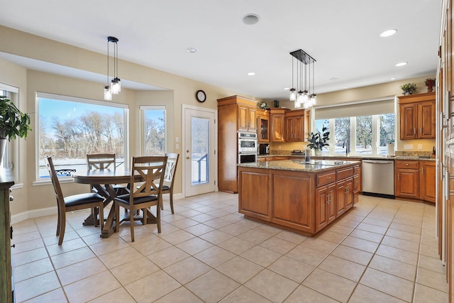 kitchen featuring a center island, light tile patterned floors, light stone counters, brown cabinets, and stainless steel appliances