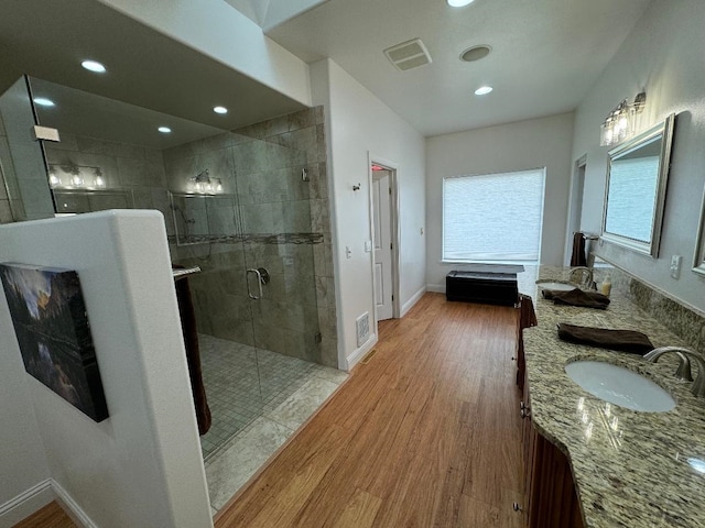 bathroom featuring hardwood / wood-style flooring, vanity, and a shower with shower door